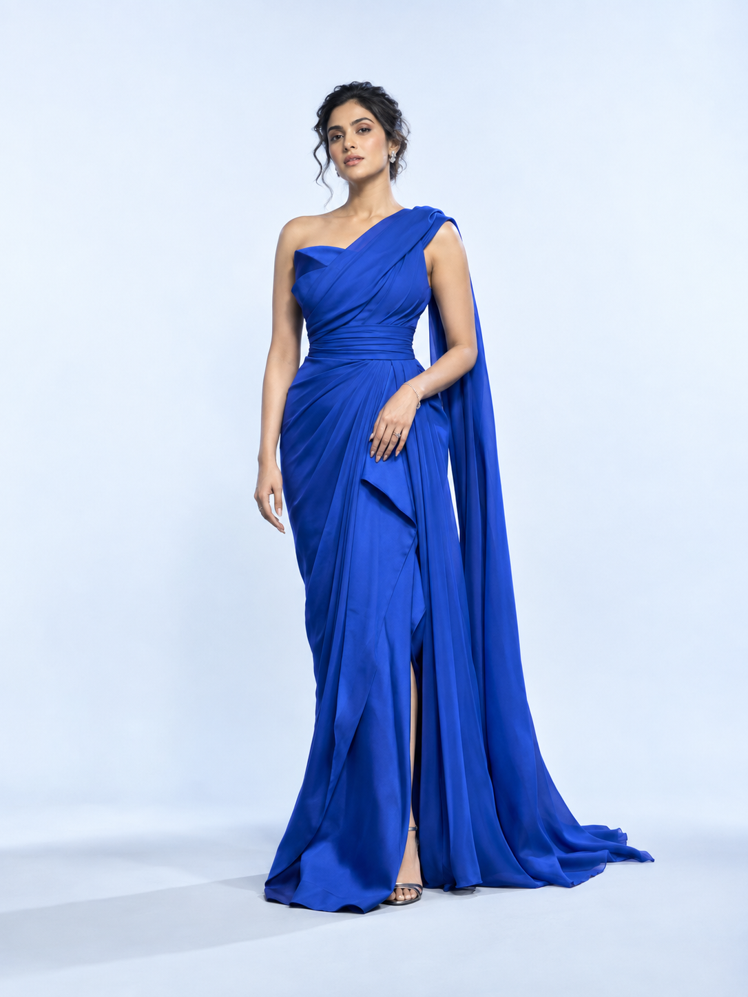 Illustrative fashion campaign: woman wearing a flowing cobalt occasion-wear gown